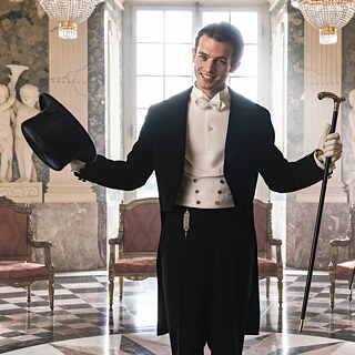 Ein eleganter junger Mann in Frack mit Zylinder und Stock