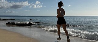 Eine Frau läuft am Strand