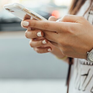 A hand of a woman holding a phone