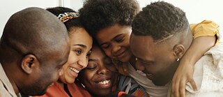 Mehrere Menschen umarmen sich.