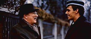 Ein älterer Mann mit Hut und ein junger Mann mit Mütze