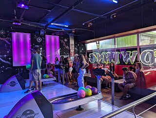 Jugendliche beim Bowling in Neonlicht
