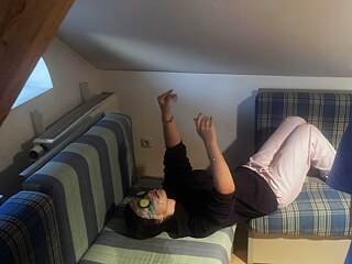 Jugendliche mit Gesichtsmaske liegt entspannt auf einer Couch.