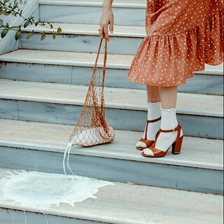 Einer Frau ist die Milch aus dem Beutel auf den Boden gefallen.