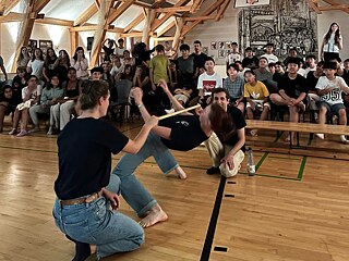 Junge Menschen beim Limbo-Tanz.