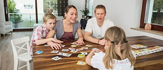 Family at living room playing parlor game together.