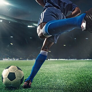 a soccer player kicking a ball