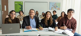 eine Gruppe von Frauen und Männern auf einer Bank sitzend