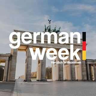 Das Bild zeigt ein Foto des Brandenburger Tors in Berlin. Im Hintergrund ein Himmel mit Wolken. Im Vordergrund steht in wei´ßer Schrift "German Week" geschrieben. Rechts neben dem Schriftzug ist ein schmaler schwarz-rot-goldener Streifen. 