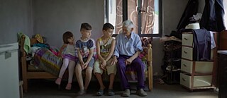 Mehrere Personen sitzen auf einem Bett