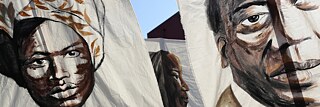 Rassismus – Drei Porträts historischer Schwarzer brasilianischer Persönlichkeiten sind auf Bannern zu sehen.