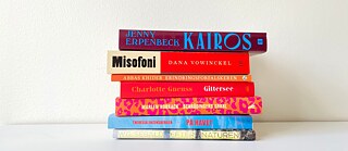 Ein Bücherstapel vor einer weißen Wand