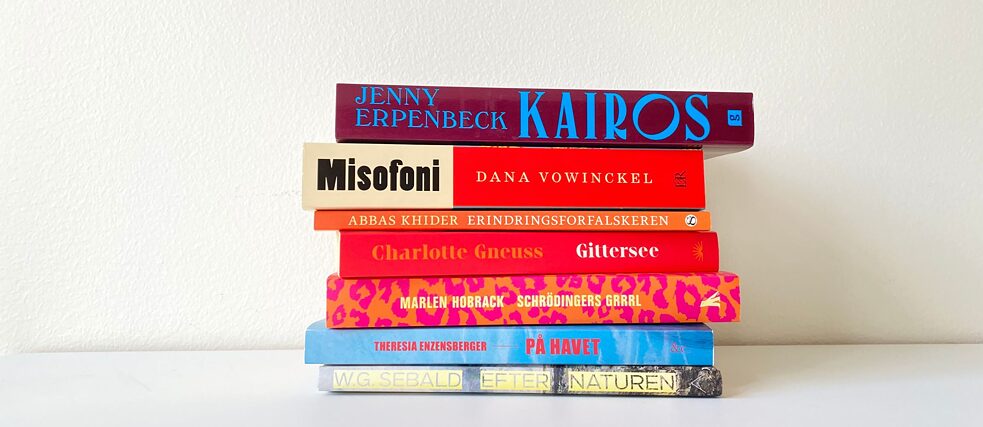 En stak bøger foran et hvidt væg. 