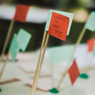 Rohelised ja punased paberlipud. Ühel lipul on inglise keeles kirjutatud „Motivation for getting offline life” (Motivatsioon offline-elu jaoks). 