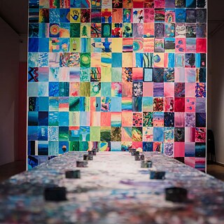 Suur seinamaal, mis koosneb paljudest värvilistest laste joonistustest.