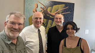 Iven Yorick Fenker and Sonali Beher stand together with Scott Denham and Reinhard von Hennigs in front of a painting.