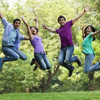 Several young students are jumping for joy in the park.