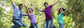 Several young students are jumping for joy in the park.