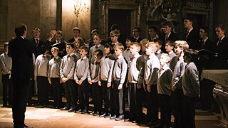 The ensemble of the Neue Knabenchor Hamburg is conducted by its director.