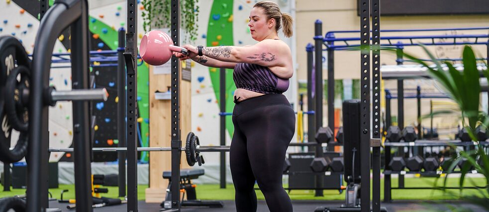 Young woman training with weights at the gym