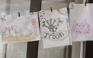 Kinderzeichnung eines grünen Monsters mit drei Köpfen.