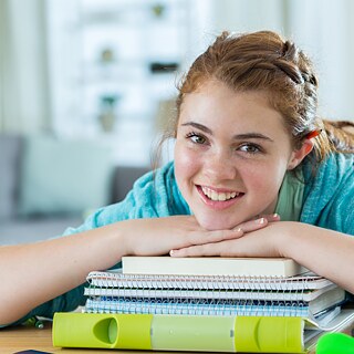 Mädchen vor einem Bücherstapel