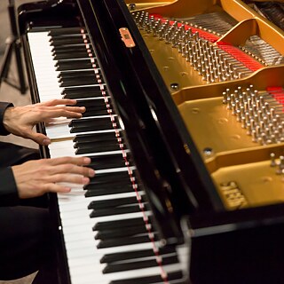 Hände auf Klaviertastatur