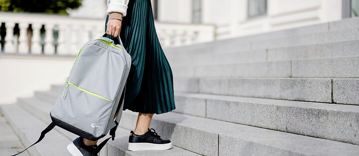 A girl wearing a skirt walking up the steps with a Goethe-Institut backpack