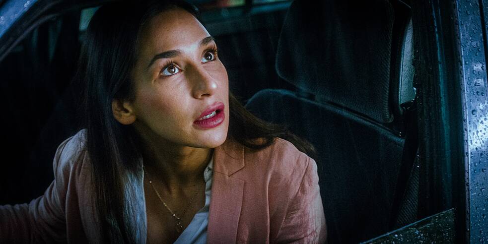 Yasemin (Yasemin Çetinkaya) sitzt am Steuer eines Pkw. Das Seitenfenster ist heruntergelassen und sie sieht beunruhigt aus dem Fenster.