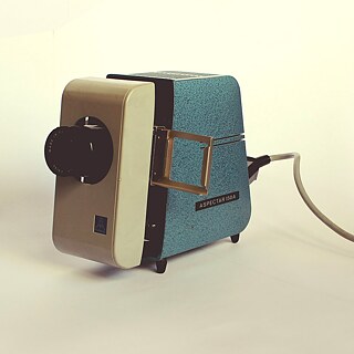 Es un dispositivo opto-mecánico con el que las diapositivas enmarcadas se amplían con luz y se proyectan en una pantalla.