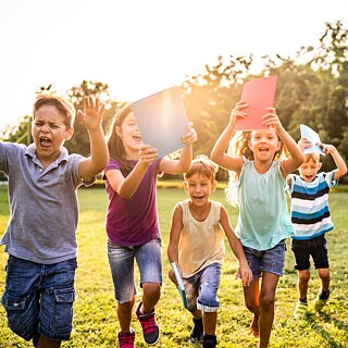 Eine Schülergruppe läuft glücklich durch den Park