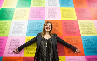 Frau vor bunten Plakaten