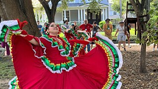 Traditionally dressed dancer with audience in the background