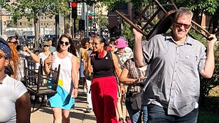 People on a walk carrying chairs