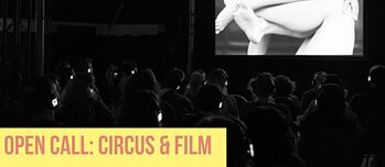 Un público con auriculares está sentado en una sala oscura viendo una película en blanco y negro en una gran pantalla, mientras en la parte inferior aparece el texto “Open Call: Circus & Film”.