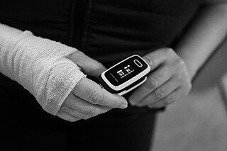 Mama s pulzným oxymetrom, ktorým pacientke zvyčajne meria saturáciu kyslíka v krvi a tepovú frekvenciu.