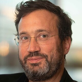 Ein Kopfbild von Eyal, einem Mann mit Bart und Brille