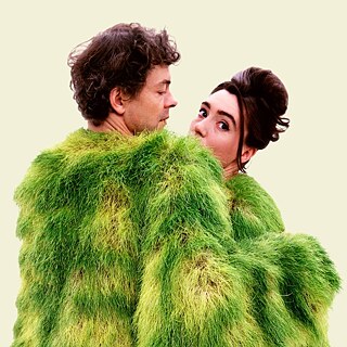 A couple in a green costume on a beige background