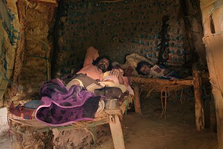 الساحل الغربي - اليمن; حياة على الساحل: ياسر مع طفلية أثناء القيلولة في احدى عششه