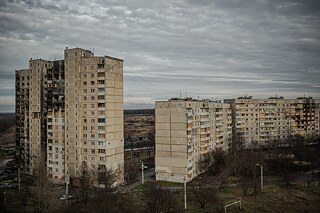 Der nördliche Stadtteil Saltiwka ist der größte und am dichtesten besiedelte Teil von Charkiw. Es handelt sich um graue, betonierte Hochhaus-Monolithen. Dahinter befindet sich eine Reihe von Garagen, und hinter den Garagen liegen Felder.