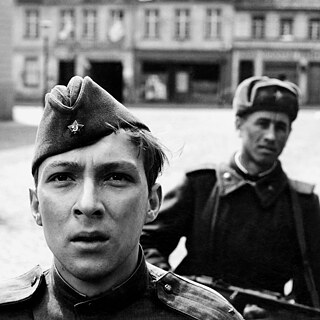 Black and white close up of a young blond soldier and another soldier in the background