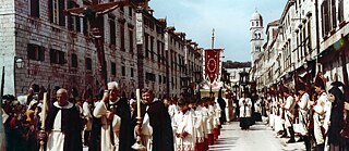 Colour image of a religious procession in a urban street.
