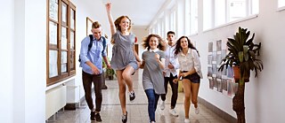 A lively group of young people sprinting along a corridor full of energy and enthusiasm