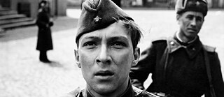 Black and white close up of a young blond soldier and another soldier in the background