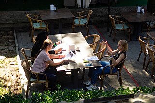 учасники сидять за столом на вулиці і спілкуються