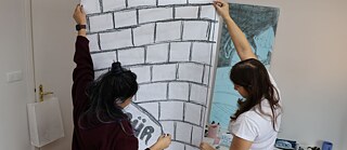 2 Bayan Afisi tutuyor