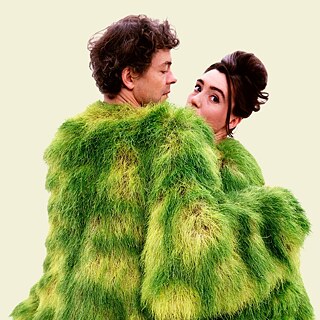 A couple in a green costume on a beige background