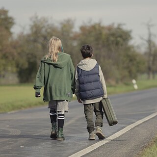 two kids walking down a rural road