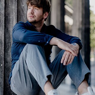 Forfatteren Dmitrij Kapitelman sidder under en betonbro og kigger ud i det fjerne.