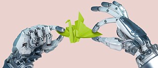 Robothänder håller en grön fågel vikad av papper.